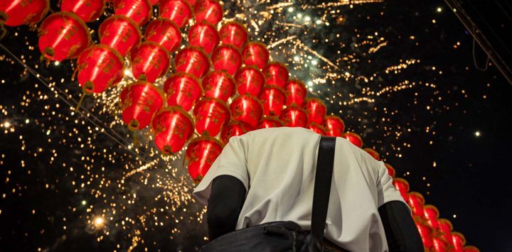 Fuegos artificiales iluminan las linternas rojas colgantes durante la peregrinación anual de Dajia Mazu en Taichung, Taiwán.