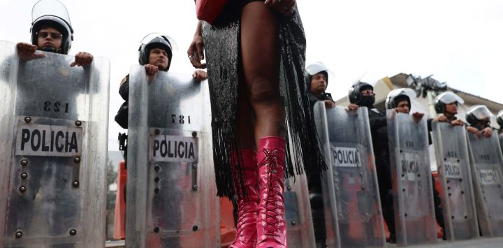 Una trabajadora sexual transgénero, se planta frente a agentes de la policía antidisturbios mexicana durante una protesta contra el carril bici Gran Tenochtitlán y la organización del Mundial de México en la Ciudad de México. El Gran Tenochtitlán es un proyecto de infraestructura diseñado para conectar el Estadio Banorte (antes Estadio Azteca) con otros puntos de interés de la Ciudad de México, según el gobierno local.