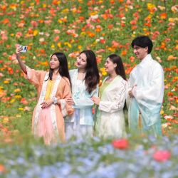 Imagen de estudiantes extranjeros tomándose fotografías con flores, en el poblado de Baitu de Jurong, en la provincia de Jiangsu, en el este de China. | Foto:Xinhua/Zhong Xueman