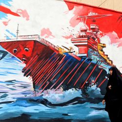 Una mujer pasa junto a un mural antiestadounidense y antiisraelí en Teherán, en medio de un alto el fuego en la región. Ante la proximidad del fin de un alto el fuego de dos semanas, la Casa Blanca anunció que el vicepresidente estadounidense estaba dispuesto a regresar a Pakistán para reanudar las negociaciones que pusieran fin a un conflicto que ha disparado el precio del petróleo y reavivado los temores inflacionarios. | Foto:ATTA KENARE / AFP