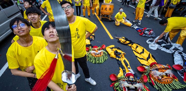 Bailarines de la danza del león observan los petardos mientras se preparan para la peregrinación anual de Dajia Mazu en Taichung, Taiwán.