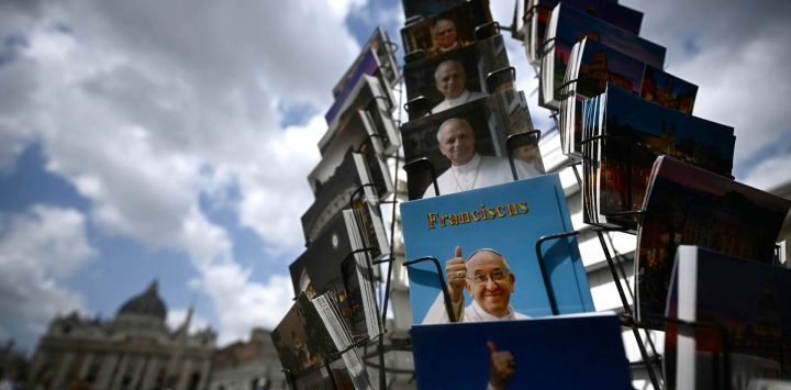 Postales con retratos del Papa Francisco y del Papa León XIV se exhiben a la venta en la Via della Conciliazione, con la Basílica de San Pedro al fondo, en Roma. Hoy se celebrará una misa en la Basílica de Santa María la Mayor en Roma para conmemorar el primer aniversario de la muerte del Papa Francisco.