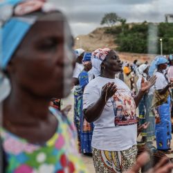 Los fieles rezan mientras el Papa León XIV dirige el rezo del Santo Rosario en la explanada frente al santuario "Mama Muxima" en Muxima, en el séptimo día de una gira apostólica de 11 días por África. | Foto:Phill Magakoe / AFP
