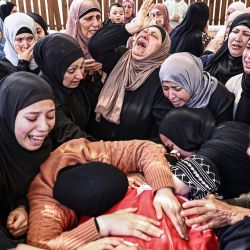 Familiares lloran la muerte de Jihad Marzouq Abu Naim durante su funeral en Al-Mughayyir, al este de Ramallah, en la Cisjordania ocupada por Israel. La Autoridad Palestina afirmó que dos palestinos, Aws Hamdi Al-Naasan, de 14 años, y Jihad Marzouq Abu Naim, de 32 años, ambos de Al-Mughayyir, murieron a causa de disparos de colonos israelíes en la Cisjordania central ocupada. El ejército israelí declaró que estaba investigando el incidente. | Foto:ZAIN JAAFAR / AFP