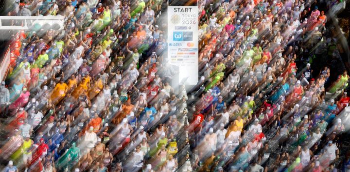 Una fotografía tomada con una velocidad de obturación lenta muestra a los corredores partiendo frente al edificio del Gobierno Metropolitano de Tokio al inicio del Maratón de Tokio en la zona de Shinjuku, en el centro de Tokio.