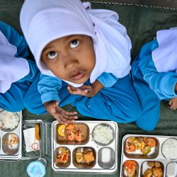 Alumnos de jardín de infancia comen alimentos proporcionados por el programa de comidas gratuitas del gobierno indonesio en Banda Aceh. | Foto:CHAIDEER MAHYUDDIN / AFP