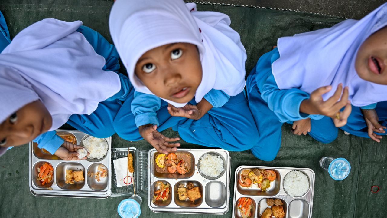 Alumnos de jardín de infancia comen alimentos proporcionados por el programa de comidas gratuitas del gobierno indonesio en Banda Aceh. | Foto:CHAIDEER MAHYUDDIN / AFP