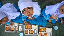 Alumnos de jardín de infancia comen alimentos proporcionados por el programa de comidas gratuitas del gobierno indonesio en Banda Aceh.