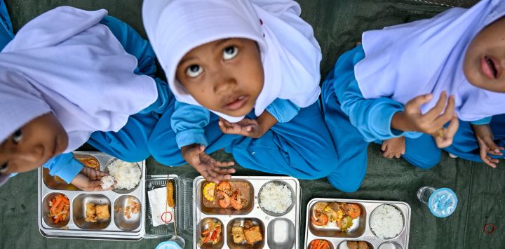 Alumnos de jardín de infancia comen alimentos proporcionados por el programa de comidas gratuitas del gobierno indonesio en Banda Aceh.