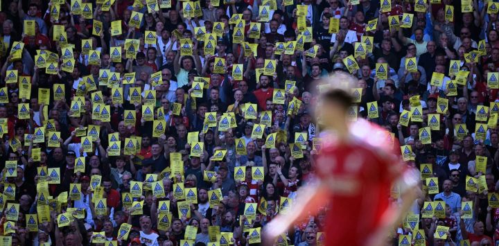 Aficionados del Liverpool alzan panfletos y pancartas que critican a los dueños del Liverpool durante el partido de fútbol de la Premier League inglesa entre el Liverpool y el Crystal Palace en Anfield, Liverpool, noroeste de Inglaterra.