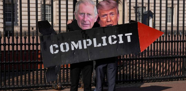 Dos miembros del grupo activista «Stop Trump Coalition» posan con un misil simulado y máscaras del rey Carlos III de Gran Bretaña y del presidente estadounidense Donald Trump frente a las puertas del Palacio de Buckingham, en el centro de Londres, para exigir el fin del apoyo del Reino Unido a Estados Unidos en los bombardeos sobre Irán.