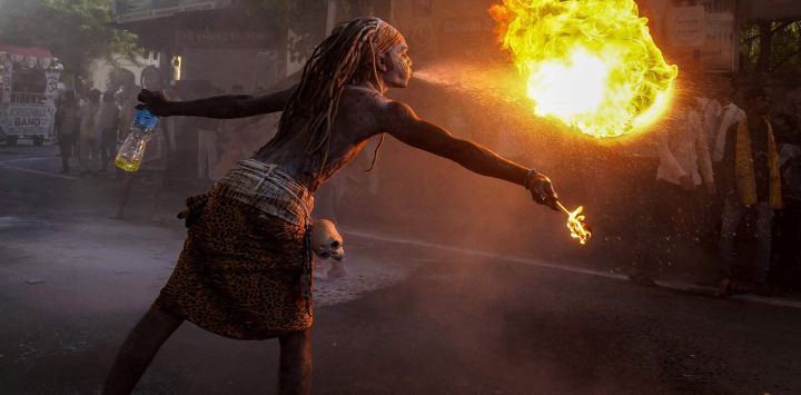 Un participante realiza un espectáculo de escupir fuego durante una procesión religiosa en Ajmer, India.