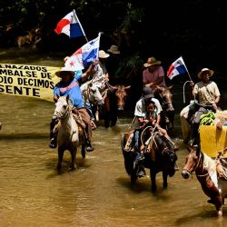 Campesinos a caballo marchan a lo largo de las orillas del río Indio con una pancarta que dice "Quienes se sienten amenazados por la represa en el río Indio dicen Presidente" para protestar contra el proyecto del río Indio en Limón de Chagres, provincia de Colón, Panamá. El proyecto del embalse del río Indio en Panamá es una prioridad estratégica para la Autoridad del Canal de Panamá (ACP) para garantizar el suministro de agua potable a más de dos millones de personas y asegurar el funcionamiento del Canal durante los próximos 50 años. | Foto:MARTIN BERNETTI / AFP
