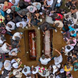 Vista aérea tomada mientras la gente asiste al entierro masivo de las víctimas de un atentado con bomba en la carretera, en el cementerio local de Cajibio, departamento del Cauca, Colombia. Doce de las 21 víctimas residían en el municipio de Cajibio. El ataque, el más mortífero contra civiles en décadas en el país, se produjo en vísperas de elecciones clave. | Foto:JOAQUIN SARMIENTO / AFP