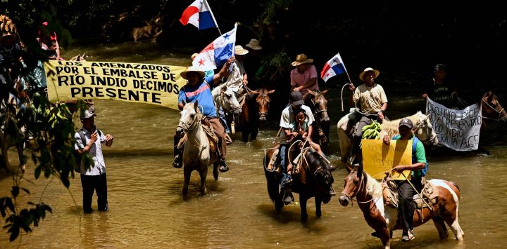 Campesinos a caballo marchan a lo largo de las orillas del río Indio con una pancarta que dice "Quienes se sienten amenazados por la represa en el río Indio dicen Presidente" para protestar contra el proyecto del río Indio en Limón de Chagres, provincia de Colón, Panamá. El proyecto del embalse del río Indio en Panamá es una prioridad estratégica para la Autoridad del Canal de Panamá (ACP) para garantizar el suministro de agua potable a más de dos millones de personas y asegurar el funcionamiento del Canal durante los próximos 50 años.