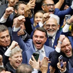 El senador Flavio Bolsonaro celebra durante una sesión del Congreso Nacional que anuló el veto del presidente Lula a un proyecto de ley que reducía las penas para los condenados por el intento de golpe de Estado y los hechos del 8 de enero de 2023 en Brasilia, Brasil. | Foto:Sergio Lima / AFP