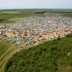 Esta fotografía, facilitada por la Gendarmería Nacional, muestra una vista aérea tomada desde un helicóptero del lugar donde se celebró una fiesta rave "teknival" en una base militar en Cornusse, cerca de Bourges, en el centro de Francia. Alrededor de 20.000 personas se congregaron para una fiesta rave ilegal en una base militar francesa, haciendo caso omiso de las advertencias sobre el riesgo de munición sin explotar y posibles explosiones. | Foto:Handout / GENDARMERIE NATIONALE / AFP