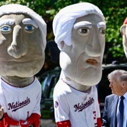 El presidente estadounidense Donald Trump pasa junto a las mascotas "Racing Presidents" del equipo de béisbol Washington Nationals a su llegada para observar a jóvenes estudiantes atletas participar en actividades físicas en el jardín sur de la Casa Blanca, luego de que el presidente Trump firmara una proclamación para reactivar el Premio Presidencial de Aptitud Física, un programa competitivo de acondicionamiento físico para escuelas, en Washington, D.C.. | Foto:Kent Nishimura / AFP
