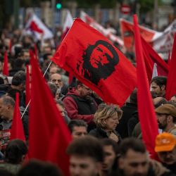 Manifestantes portan una bandera con la imagen del revolucionario cubano-argentino Ernesto "Che" Guevara durante una concentración en Atenas, Grecia. | Foto:ARIS MESSINIS / AFP