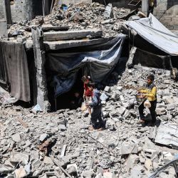 Niños palestinos desplazados transportan ollas de comida recogidas en un comedor social hasta el refugio de su familia, bajo los escombros de los edificios destruidos por el ejército israelí, en el campamento de refugiados de Bureij, en el centro de la Franja de Gaza. La guerra en la Franja de Gaza se desencadenó tras el ataque del grupo militante palestino Hamás contra Israel el 7 de octubre de 2023, que causó la muerte de 1.221 personas. El ataque de represalia de Israel contra Gaza ha dejado al menos 72.600 muertos, según cifras del Ministerio de Salud que la ONU considera fiables, y la mayoría de los 2,4 millones de habitantes de Gaza son personas desplazadas. | Foto:Eyad Baba / AFP