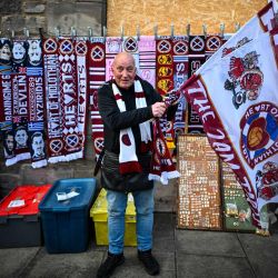 Un vendedor ofrece productos a las afueras del estadio tras el partido de la Premiership escocesa entre el Hearts y el Rangers en el estadio Tynecastle de Edimburgo. El Hearts aspira a convertirse en el primer club, aparte del Celtic y el Rangers, en ganar el título escocés desde el Aberdeen en 1985. | Foto:Andy Buchanan / AFP