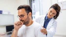 Doctora escucha los pulmones del paciente.