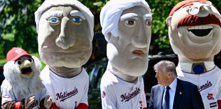 El presidente estadounidense Donald Trump pasa junto a las mascotas "Racing Presidents" del equipo de béisbol Washington Nationals a su llegada para observar a jóvenes estudiantes atletas participar en actividades físicas en el jardín sur de la Casa Blanca, luego de que el presidente Trump firmara una proclamación para reactivar el Premio Presidencial de Aptitud Física, un programa competitivo de acondicionamiento físico para escuelas, en Washington, D.C..