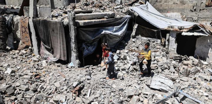 Niños palestinos desplazados transportan ollas de comida recogidas en un comedor social hasta el refugio de su familia, bajo los escombros de los edificios destruidos por el ejército israelí, en el campamento de refugiados de Bureij, en el centro de la Franja de Gaza. La guerra en la Franja de Gaza se desencadenó tras el ataque del grupo militante palestino Hamás contra Israel el 7 de octubre de 2023, que causó la muerte de 1.221 personas. El ataque de represalia de Israel contra Gaza ha dejado al menos 72.600 muertos, según cifras del Ministerio de Salud que la ONU considera fiables, y la mayoría de los 2,4 millones de habitantes de Gaza son personas desplazadas.