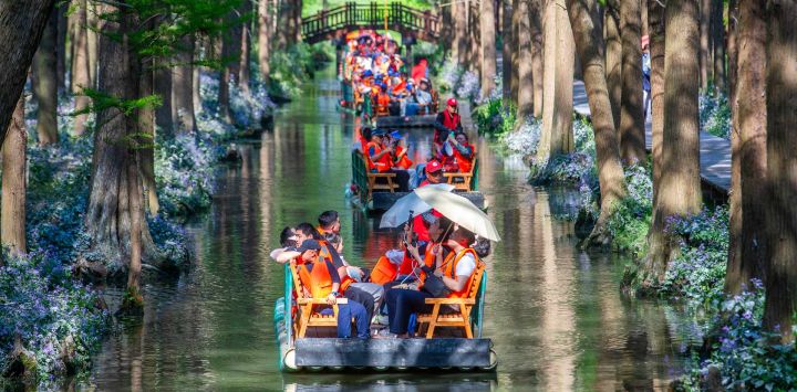 Turistas disfrutan del paisaje a bordo de balsas en un parque nacional de humedales, en la ciudad de Xinghua, en la provincia de Jiangsu, en el este de China.
