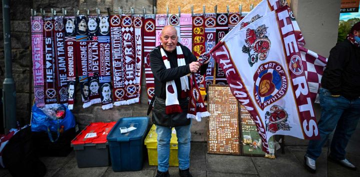 Un vendedor ofrece productos a las afueras del estadio tras el partido de la Premiership escocesa entre el Hearts y el Rangers en el estadio Tynecastle de Edimburgo. El Hearts aspira a convertirse en el primer club, aparte del Celtic y el Rangers, en ganar el título escocés desde el Aberdeen en 1985.