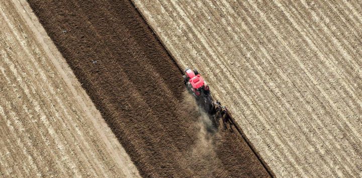 Vista aérea tomada con un dron de un agricultor conduciendo maquinaria agrícola para arar los campos, en la región autónoma de Mongolia Interior, en el norte de China.