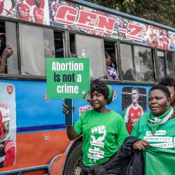 Activistas por los derechos reproductivos portan pancartas y corean consignas junto a un autobús público durante una marcha en defensa del acceso a la atención médica reproductiva y en protesta contra las leyes que penalizan el aborto y restringen los servicios de salud para mujeres y niñas en el centro de Nairobi, Kenia. | Foto:LUIS TATO / AFP