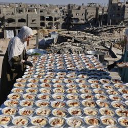 Las hermanas palestinas Lina Zeid y Aya Zeid preparan platos de comida en la azotea de su casa para distribuirlos entre niños desplazados como acto de caridad en la zona de Al-Tuam, al oeste de Jabalia, en el norte de la Franja de Gaza. Funcionarios de salud de Gaza informaron que los ataques israelíes causaron la muerte de cinco personas y dejaron varios heridos en todo el territorio palestino. A pesar del alto el fuego de octubre, Gaza sigue sumida en la violencia diaria debido a los continuos ataques israelíes, y tanto el ejército como Hamás se acusan mutuamente de violar la tregua. | Foto:OMAR AL-QATTAA / AFP