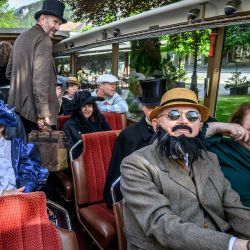 Miembros de la Sociedad Sherlock Holmes de Londres, sentados en un autobús antiguo durante su viaje a las cataratas de Reichenbach, cerca de Meiringen. Ataviados impecablemente con trajes victorianos, los devotos de Sherlock Holmes viajaron a las cataratas de Reichenbach, en Suiza, para recrear el duelo fatal del intrépido detective con su archienemigo, el profesor Moriarty, 135 años después. | Foto:FABRICE COFFRINI / AFP