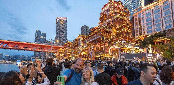 Imagen de turistas extranjeros tomándose fotografías frente al Area Escénica de Hongyadong, en el distrito de Yuzhong de Chongqing, en el suroeste de China. Mientras disfrutan de la deliciosa comida, contemplan los paisajes y experimentan la colorida cultura, los turistas extranjeros también se ven inmersos en la "sensación de seguridad china", que generalmente se refiere a la libertad de pasear solos a altas horas de la noche, la facilidad para recuperar pertenencias perdidas u olvidadas y la tranquilidad que se siente cuando los niños pequeños se divierten solos en la comunidad.