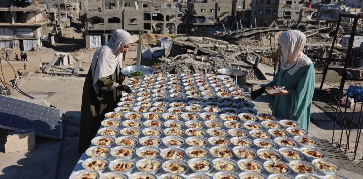 Las hermanas palestinas Lina Zeid y Aya Zeid preparan platos de comida en la azotea de su casa para distribuirlos entre niños desplazados como acto de caridad en la zona de Al-Tuam, al oeste de Jabalia, en el norte de la Franja de Gaza. Funcionarios de salud de Gaza informaron que los ataques israelíes causaron la muerte de cinco personas y dejaron varios heridos en todo el territorio palestino. A pesar del alto el fuego de octubre, Gaza sigue sumida en la violencia diaria debido a los continuos ataques israelíes, y tanto el ejército como Hamás se acusan mutuamente de violar la tregua.