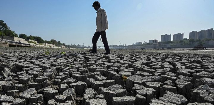 Un hombre camina sobre el lecho seco del río Sabarmati en Ahmedabad, India.