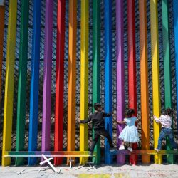 Niños juegan escalando el muro fronterizo entre México y Estados Unidos en Playas de Tijuana, estado de Baja California, México. | Foto:Guillermo Arias / AFP