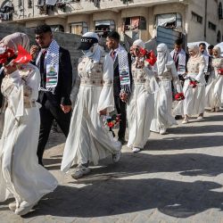 Novios palestinos se reúnen durante una celebración de bodas colectivas organizada por la Fundación Turca de Ayuda Humanitaria (IHH) en la ciudad de Gaza. | Foto:OMAR AL-QATTAA / AFP