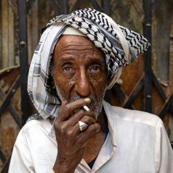 Un hombre fuma un cigarrillo sentado en una zona de mercado en la ciudad de Basora, al sur de Irak. | Foto:Hussein Faleh / AFP