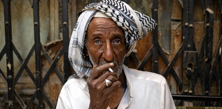 Un hombre fuma un cigarrillo sentado en una zona de mercado en la ciudad de Basora, al sur de Irak.