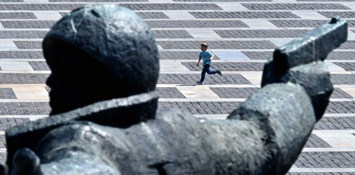 Un niño corre junto al monumento "El cruce del Dniéper" en el Museo Nacional de la Historia de Ucrania en la Segunda Guerra Mundial, un día después del Día de la Victoria sobre el nazismo en la Segunda Guerra Mundial, en Kiev, en medio de la invasión rusa de Ucrania.