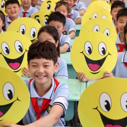 Estudiantes que sostienen tarjetas con caras sonrientes son vistos en una escuela primaria, en la ciudad de Zaozhuang, en la provincia de Shandong, en el este de China. | Foto:Xinhua/Sun Zhongzhe