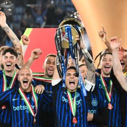 El delantero argentino del Inter de Milán, Lautaro Martínez, levanta el trofeo de la Copa Italia y celebra con sus compañeros tras la victoria del Inter en la final entre la Lazio de Roma y el Inter de Milán, disputada en el Estadio Olímpico de Roma. | Foto:ALBERTO PIZZOLI / AFP