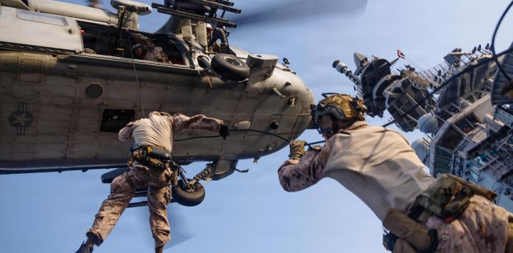 Esta foto de la Infantería de Marina de los EE. UU., muestra a infantes de marina estadounidenses de la Fuerza de Asalto Marítimo descendiendo en rápel desde un MH-60S Sea Hawk, asignado al Escuadrón de Combate Marítimo de Helicópteros 25, durante un entrenamiento de mantenimiento de helicópteros y cuerdas a bordo del buque de asalto anfibio desplegado en alta mar USS Tripoli.