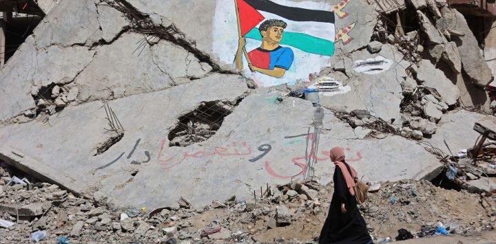 Una mujer pasa junto a un mural que representa al futbolista Lamine Yamal ondeando una bandera palestina durante el desfile de celebración del título del Catalán, pintado por artistas palestinos sobre los escombros de edificios destruidos durante la guerra, en el campamento de refugiados de Shati (Playa) en la ciudad de Gaza. El alto representante de Gaza en la Junta de Paz del presidente estadounidense Donald Trump declaró que el frágil alto el fuego en territorio palestino se mantenía a pesar de las violaciones diarias.