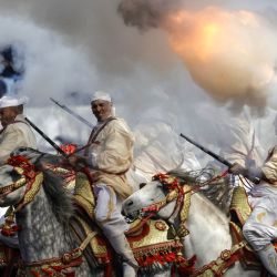 Hombres vestidos con atuendos tradicionales montan a caballo y disparan sus rifles durante una representación ecuestre de Tbourida, o Fantasía, en la ciudad de Bouznika, Marruecos. | Foto:Abdel Majid Bziouat / AFP