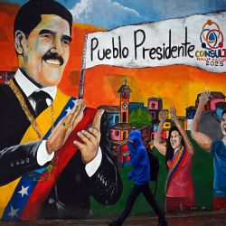 Un hombre camina frente a un mural que representa al derrocado presidente venezolano Nicolás Maduro en Caracas, Venezuela. | Foto:Federico Parra / AFP