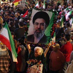 Un hombre sostiene un retrato del líder supremo de Irán, el ayatolá Mojtaba Khamenei, durante la ceremonia de despedida de la selección nacional de fútbol de Irán antes de su partida hacia la Copa Mundial de la FIFA 2026, en Teherán. El presidente de la Federación Iraní de Fútbol declaró que si Irán se retiraba del Mundial, el país perdería un "importante activo diplomático". La FIFA, organismo rector del fútbol mundial, ha insistido durante semanas en que Irán participará. Irán, que tendrá su sede en Tucson, Arizona, durante el Mundial, se enfrenta a Nueva Zelanda, Bélgica y Egipto en el Grupo G. Los iraníes debutarán en el Mundial contra Nueva Zelanda en Los Ángeles. | Foto:ATTA KENARE / AFP
