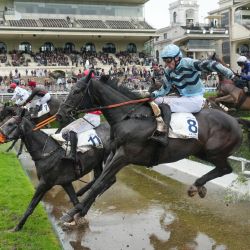 El jinete británico James Revely, montando a "Kolocico", salta un obstáculo de agua durante la 148ª edición de la carrera de obstáculos "Grand Steeple-Chase de Paris" en el Hipódromo de Auteuil, en París. | Foto:DIMITAR DILKOFF / AFP